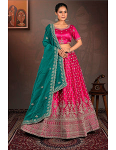 Woman wearing a pink and green traditional lehenga choli with dupatta