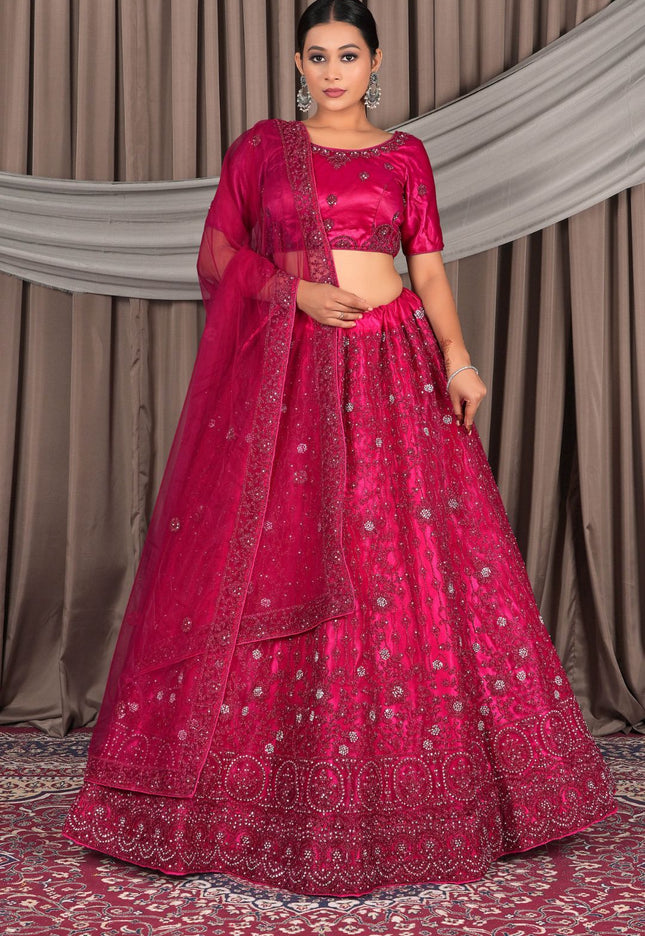 Woman wearing a traditional pink embroidered outfit with a dupatta
