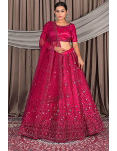 Woman wearing a traditional pink embroidered outfit with a dupatta
