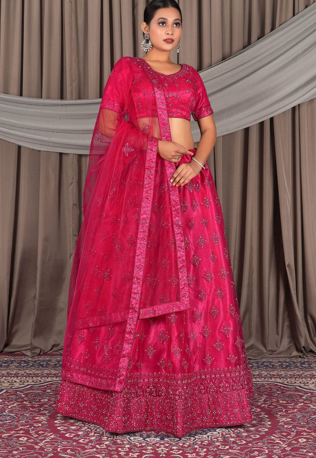 Woman wearing a traditional pink embroidered lehenga choli with dupatta