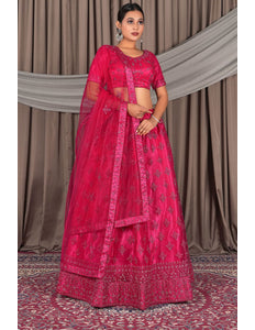 Woman wearing a traditional pink embroidered lehenga choli with dupatta