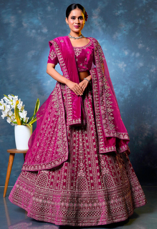 Woman in a traditional pink embroidered lehenga choli with dupatta