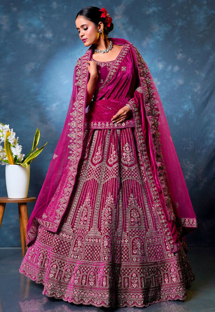 Woman in a traditional pink embroidered lehenga choli with dupatta