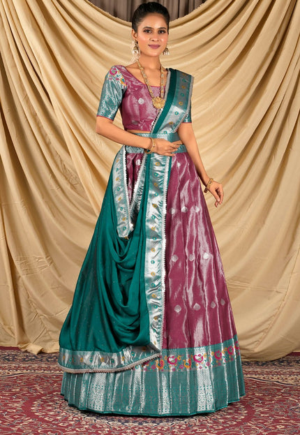 Woman wearing a traditional outfit with a green and pink lehenga choli