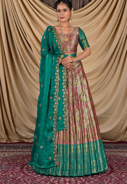 Woman wearing a traditional green and pink lehenga with a gold border