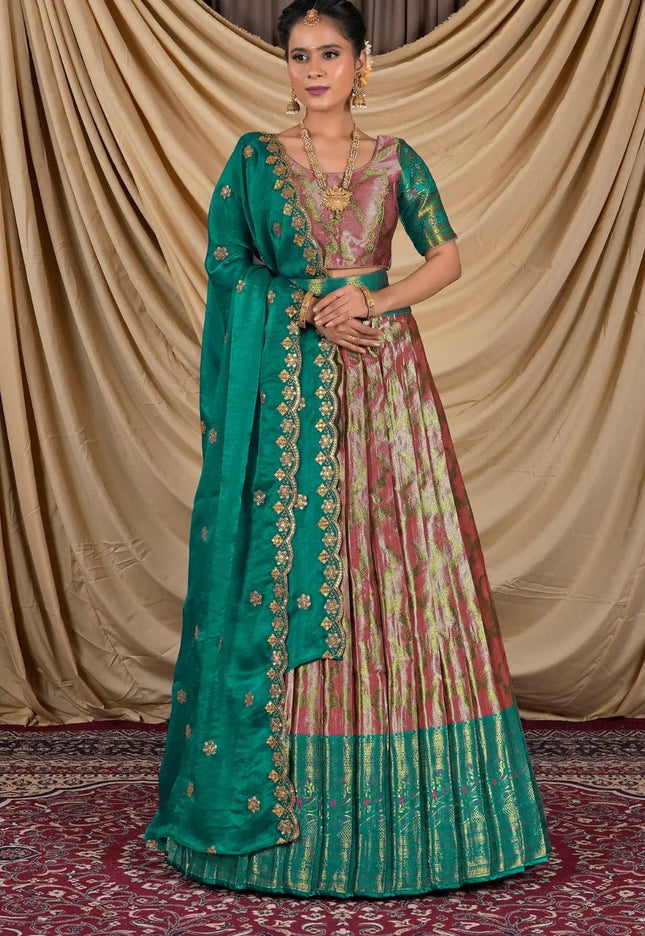 Woman wearing a traditional green and pink lehenga with a gold border
