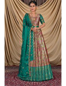 Woman wearing a traditional green and pink lehenga with a gold border