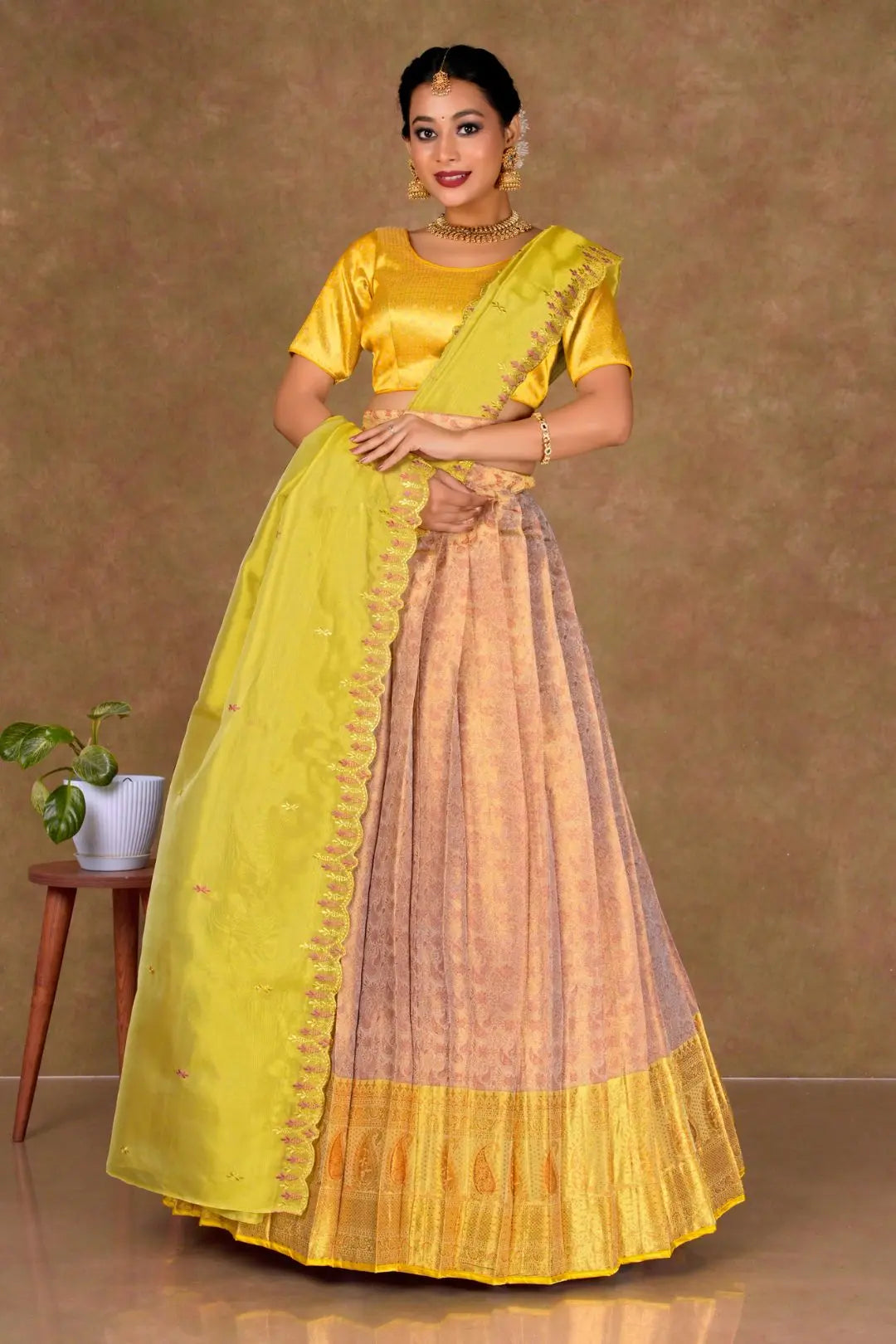 Woman wearing a Rust Lehenga with a Yellow blouse