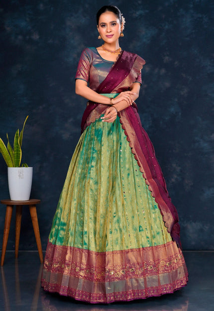 Woman wearing a green and purple lehenga choli with dupatta