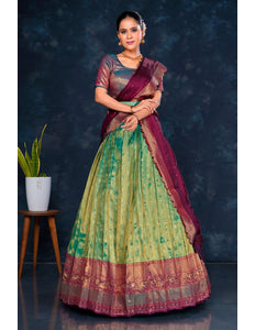Woman wearing a green and purple lehenga choli with dupatta