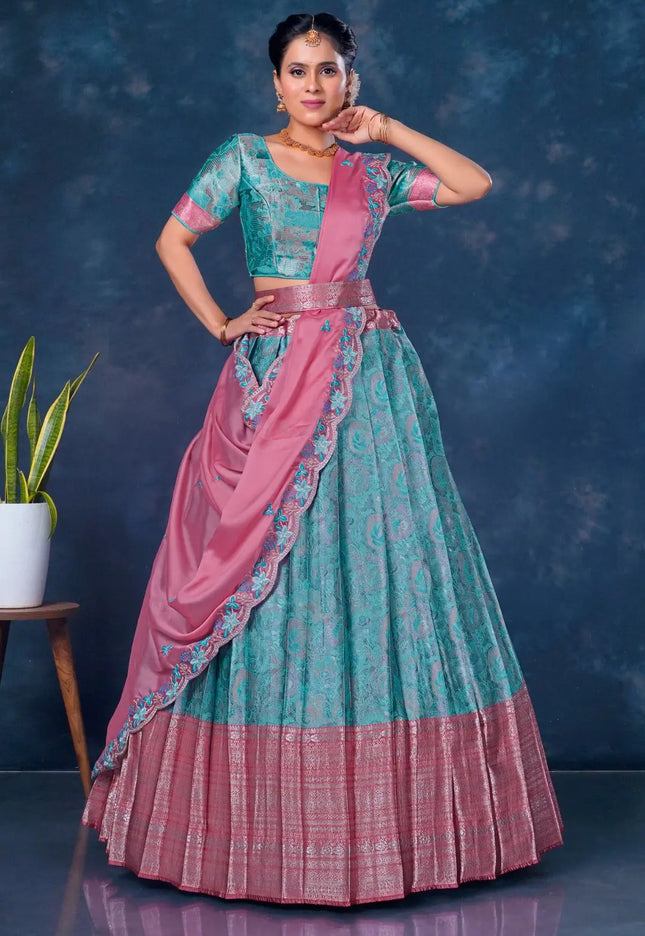 Woman wearing a traditional sea green and pink lehenga