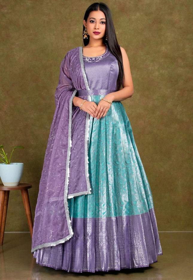 Woman wearing a purple and teal traditional outfit with a matching dupatta