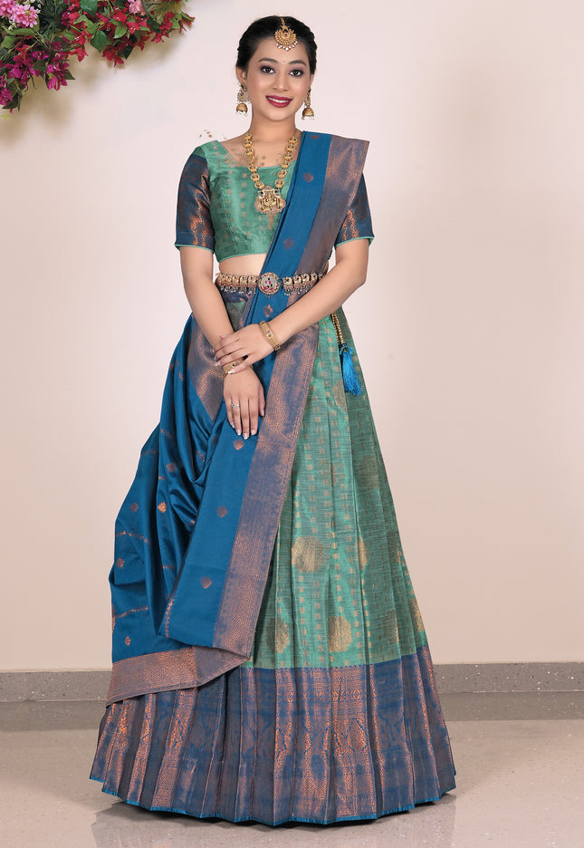 Woman wearing a traditional lehenga with a green and blue color scheme