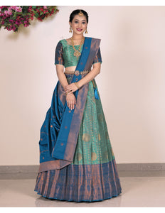 Woman wearing a traditional lehenga with a green and blue color scheme
