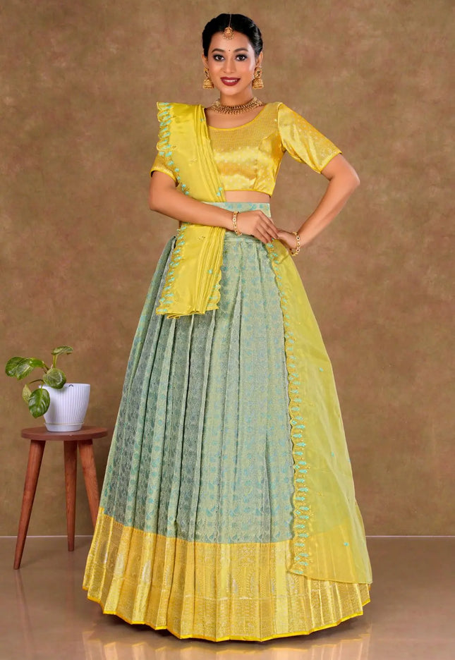 Woman wearing a yellow and green traditional lehenga choli with dupatta