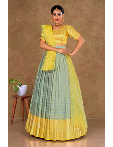 Woman wearing a yellow and green traditional lehenga choli with dupatta