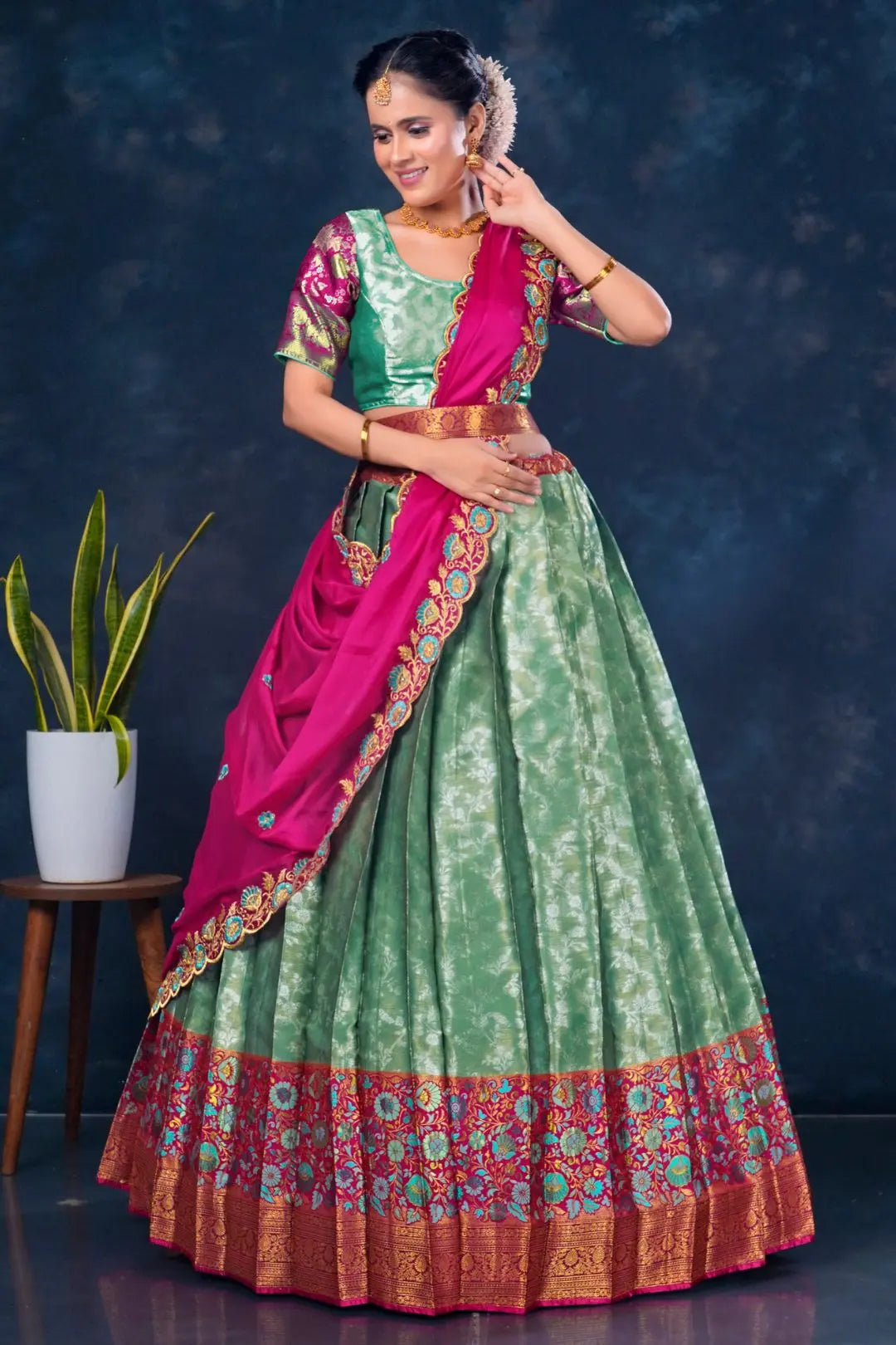 Woman wearing a green and pink traditional lehenga choli with dupatta