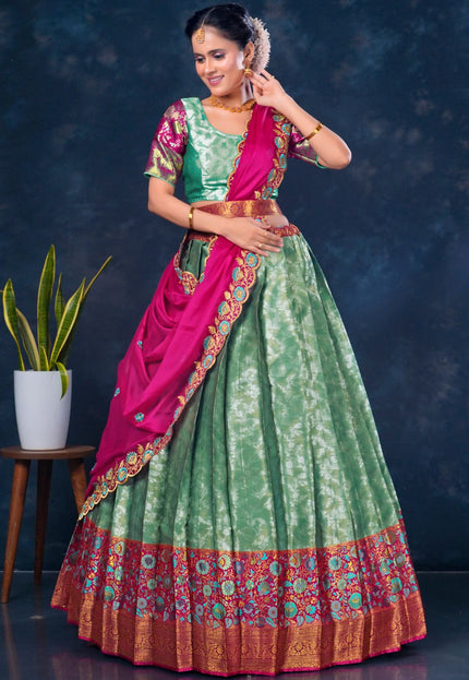 Woman wearing a green and pink traditional lehenga choli with dupatta