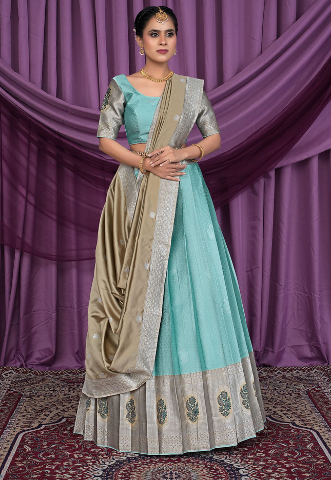 Woman wearing a traditional outfit with a sea green lehenga choli and beige dupatta