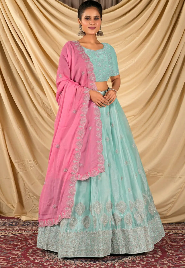 Woman wearing a light blue and pink traditional lehenga choli with dupatta