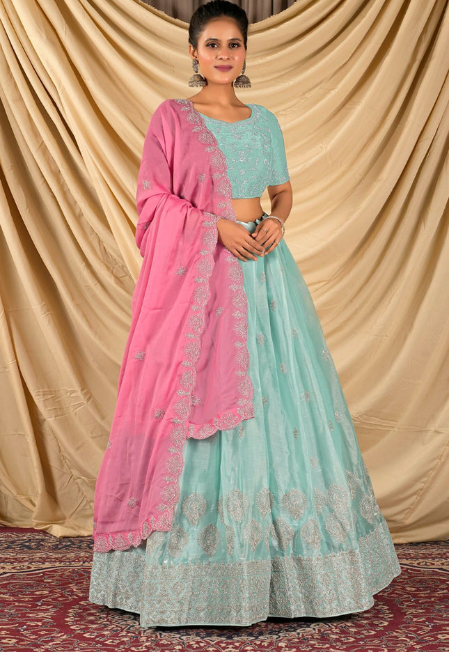 Woman wearing a light blue and pink traditional lehenga choli with dupatta