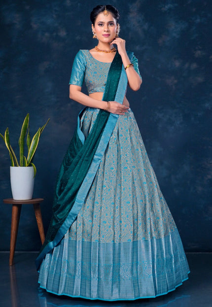 Woman in a traditional teal outfit with a matching dupatta