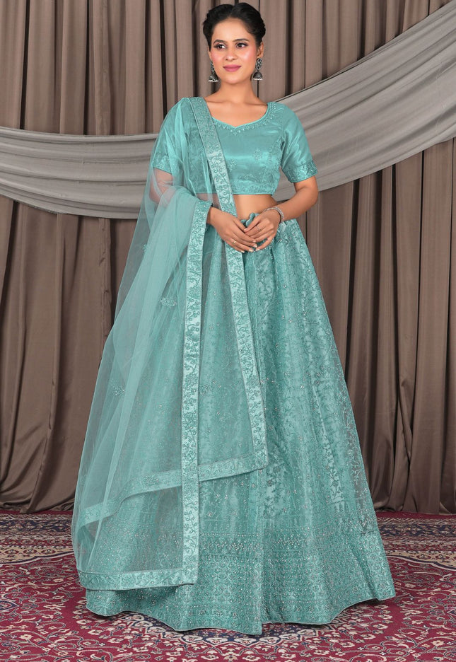 Woman wearing a teal traditional outfit with a matching dupatta