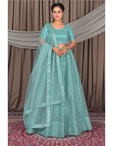 Woman wearing a teal traditional outfit with a matching dupatta