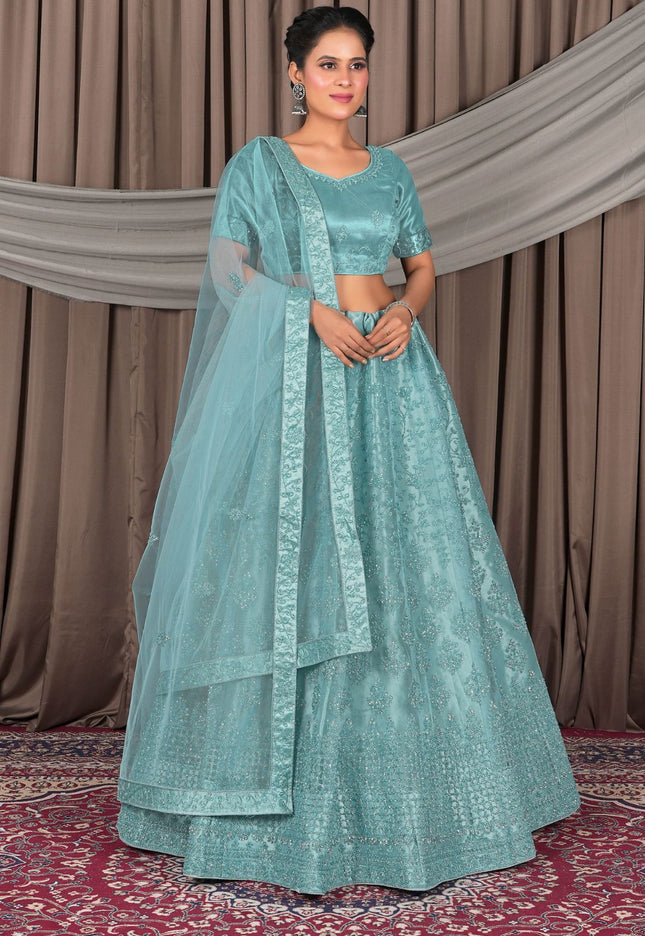 Woman in a teal traditional outfit with a dupatta