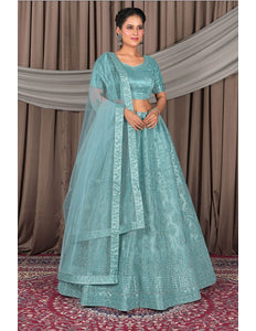 Woman in a teal traditional outfit with a dupatta
