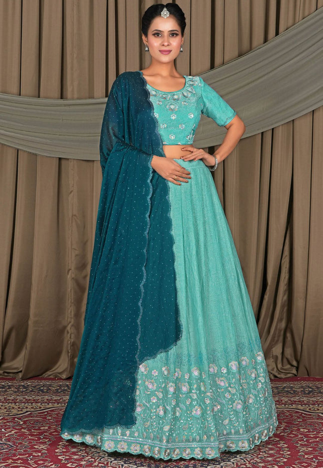 Woman wearing a traditional outfit with a teal dupatta and light blue dress