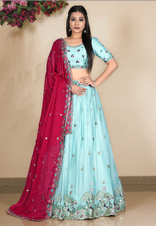 Woman wearing a light blue lehenga with pink dupatta