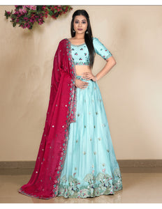 Woman wearing a light blue lehenga with pink dupatta