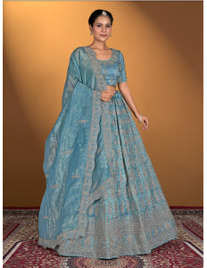 Woman wearing a blue traditional outfit with a matching dupatta