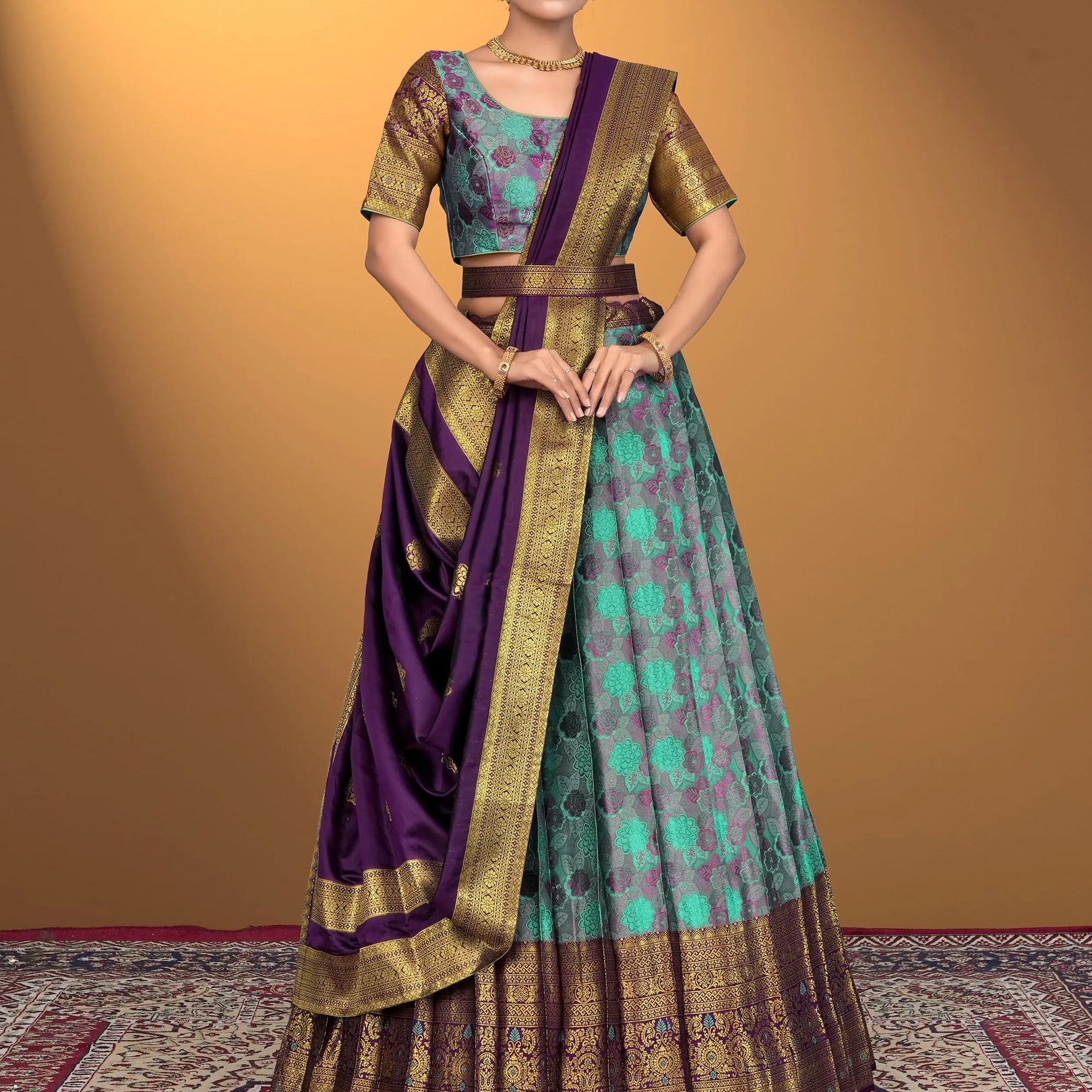 Woman wearing a traditional outfit with a purple and sea green lehenga choli