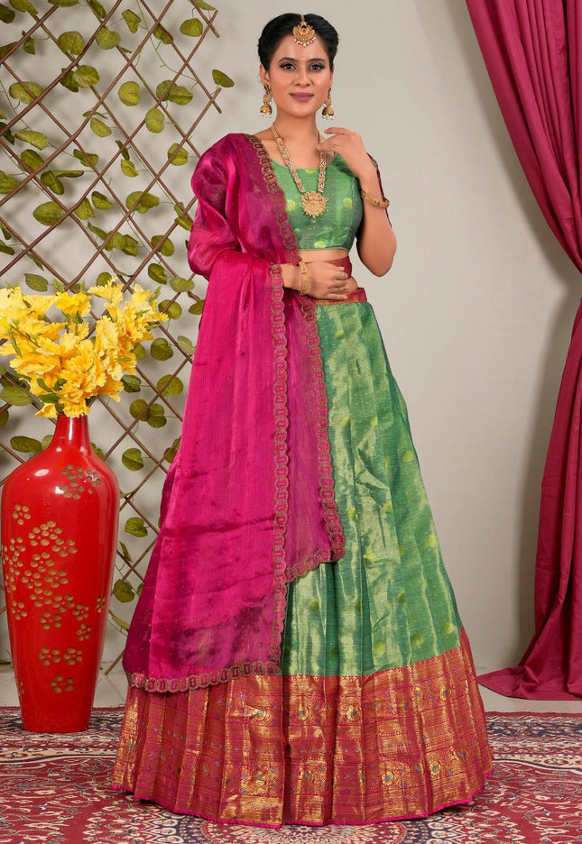 Woman wearing a green and pink traditional lehenga choli with dupatta