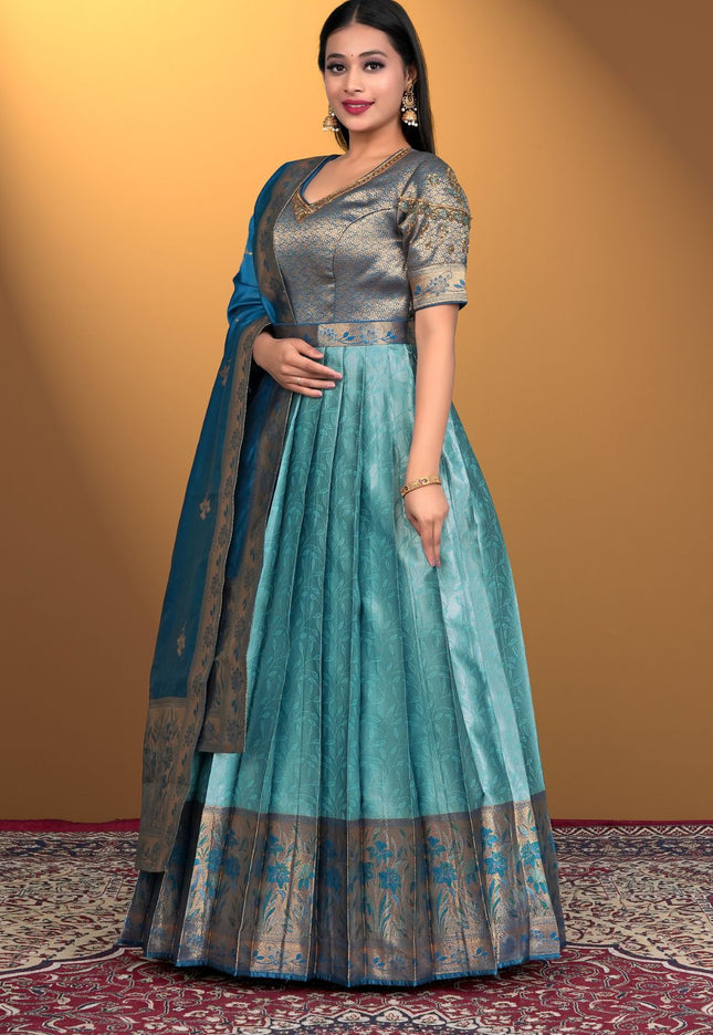 Woman wearing a traditional outfit with a sea green gown with firozi dupatta