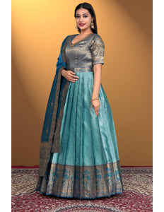 Woman wearing a traditional outfit with a sea green gown with firozi dupatta