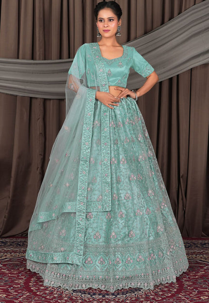 Woman wearing a light blue embroidered traditional outfit with a dupatta