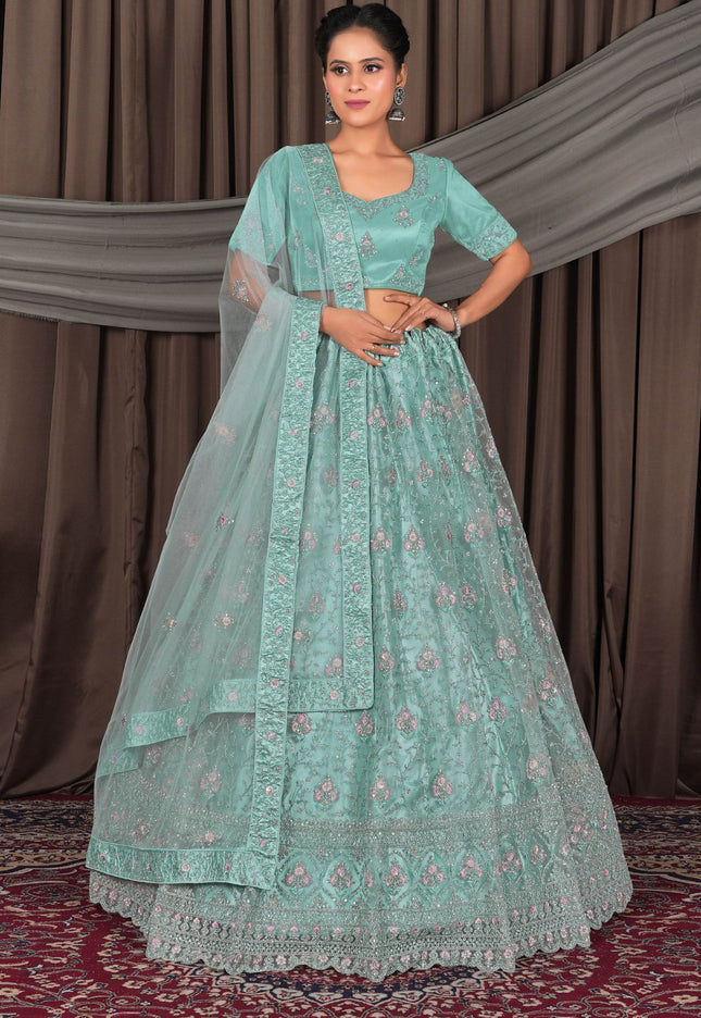 Woman wearing a light blue embroidered traditional outfit with a dupatta