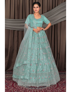 Woman wearing a light blue embroidered traditional outfit with a dupatta