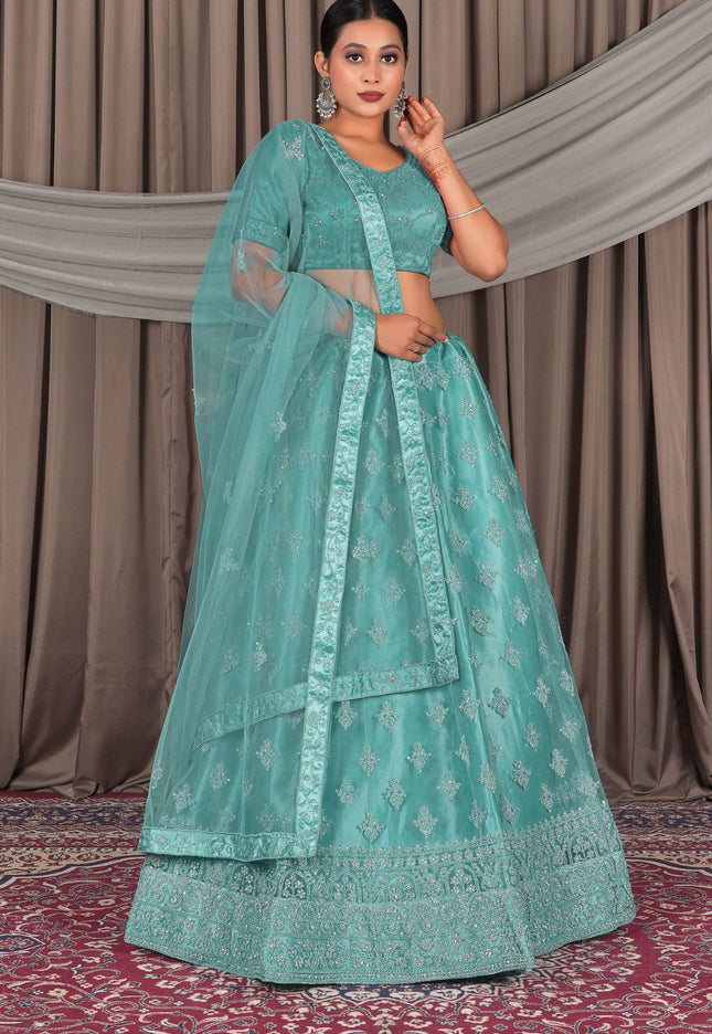 Woman wearing a teal embroidered lehenga with a matching blouse
