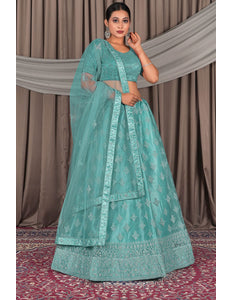 Woman wearing a teal embroidered lehenga with a matching blouse