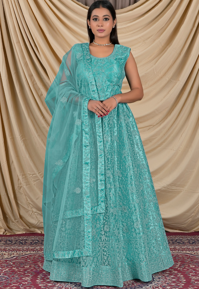 Woman wearing a sea green traditional outfit with a matching dupatta