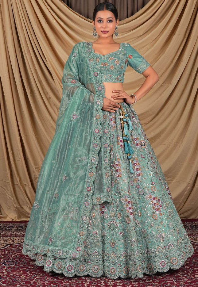 Woman wearing a traditional green embroidered lehenga choli with dupatta