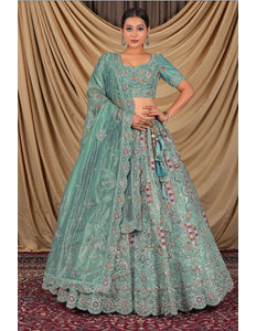 Woman wearing a traditional green embroidered lehenga choli with dupatta