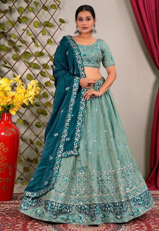 Woman wearing a teal embroidered lehenga with a contrast dupatta
