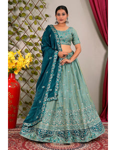 Woman wearing a teal embroidered lehenga with a contrast dupatta