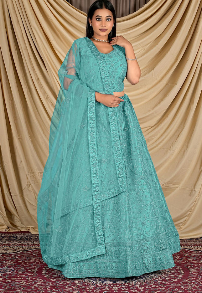 Woman wearing a teal traditional outfit with a matching dupatta