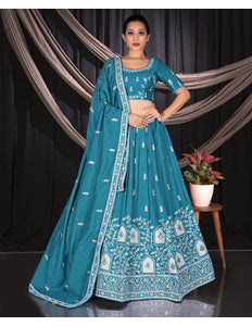 Woman wearing a teal embroidered traditional lehenga